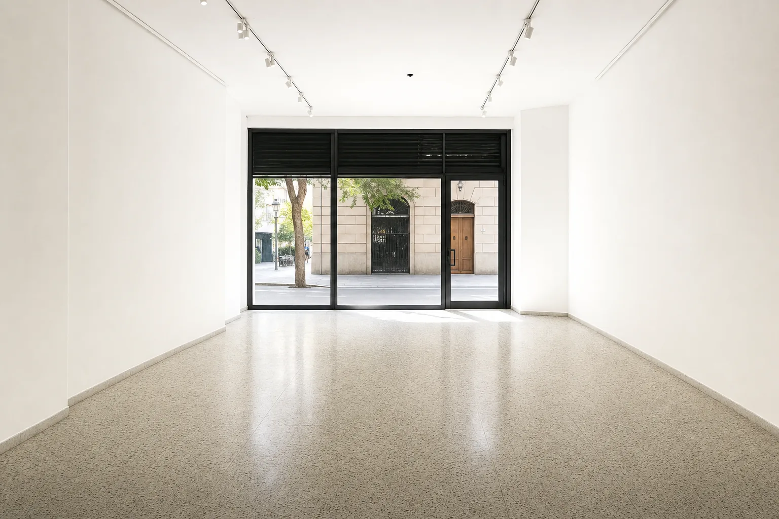 Local comercial de Barcelona completamente vacío, con el suelo de terrazo barrido y las paredes repasadas, listo para volver a alquilar
